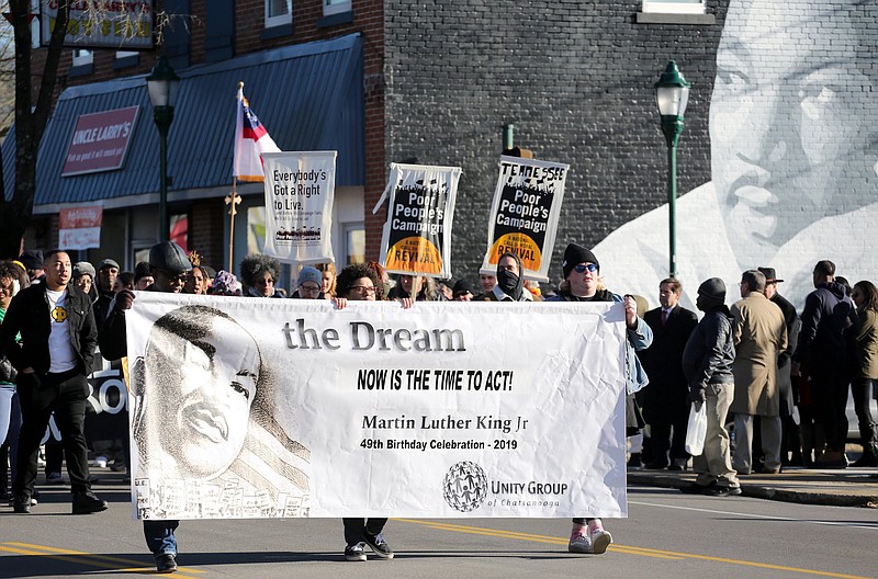 Staff photo by Erin O. Smith / Members of the Unity Group of Chattanooga march with a banner during the MLK Day march Monday, January 21, 2019 in Chattanooga, Tennessee. Despite the freezing temperatures, a few hundred people showed up to march or watch along the route Monday.