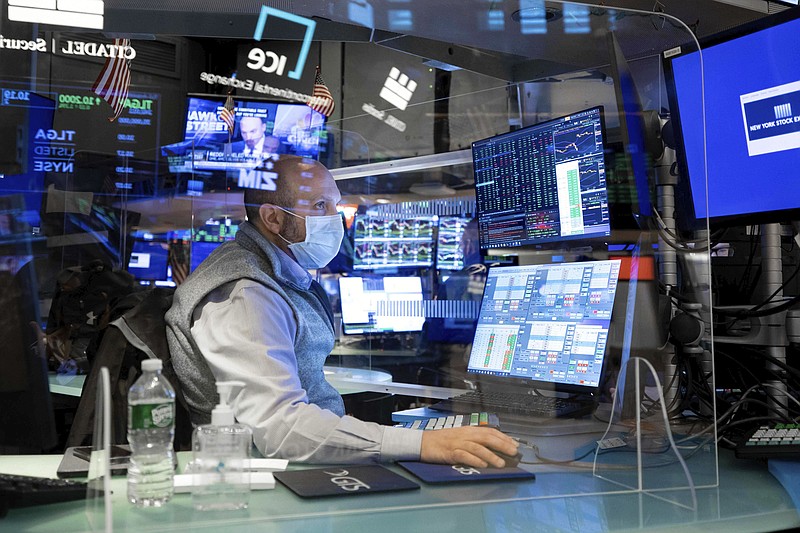 In this photo provided by the New York Stock Exchange, specialist James Denaro works at a post on the trading floor, Monday, Feb. 1, 2021. The erratic trading in shares of underdog companies like GameStop that turned markets combustible last week appears to have migrated to commodities, sending silver prices surging to an eight-year high. (Nicole Pereira/New York Stock Exchange via AP)