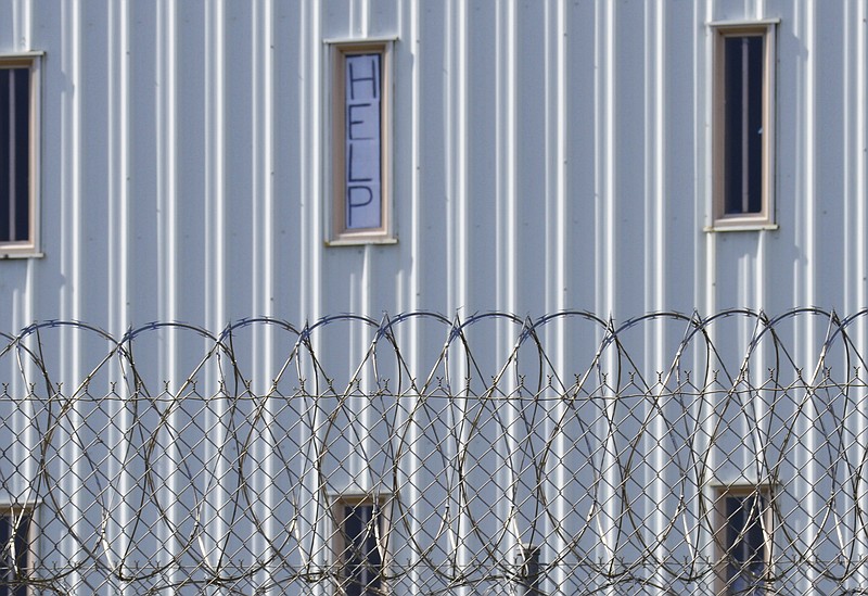 In this Oct. 22, 2019, file photo, a sign that reads, "HELP," is posted in the window of an inmate cell during a tour along with state officials at Holman Correctional Facility in Atmore, Ala. The U.S. Department of Justice filed a lawsuit Wednesday, Dec. 9, 2020, against Alabama over conditions in the state prisons, saying the state is failing to protect male inmates from inmate-on-inmate violence and excessive force at the hands of prison staff. (AP Photo/Kim Chandler, File)