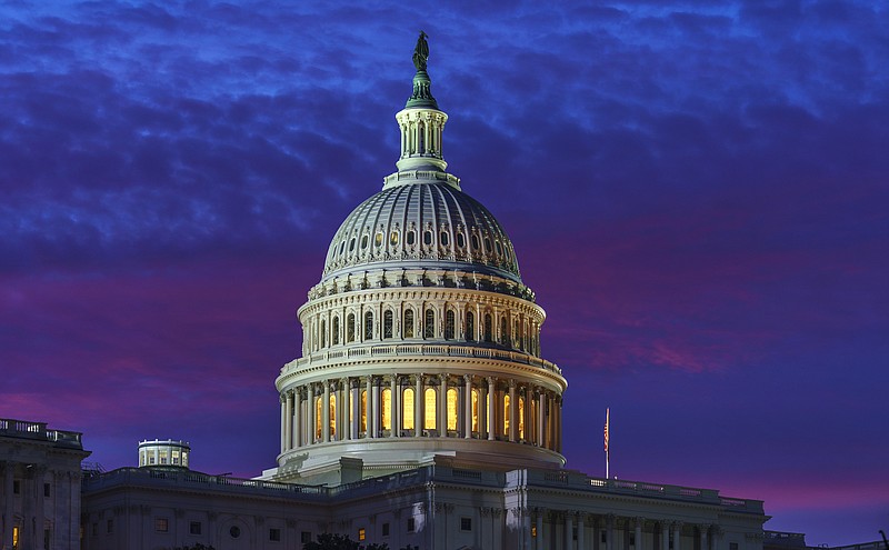 In the Nov. 6, 2020, file photo, shades of red and blue light of dawn fills the sky behind Capitol Hill in Washington. According to a new poll by The Associated Press-NORC Center for Public Affairs Research, about half of Americans say the Senate should vote to convict former President Donald Trump at the end of his impeachment trial. And a majority think he bears at least some blame for the Capitol insurrection on Jan. 6. (AP Photo/J. Scott Applewhite, File)