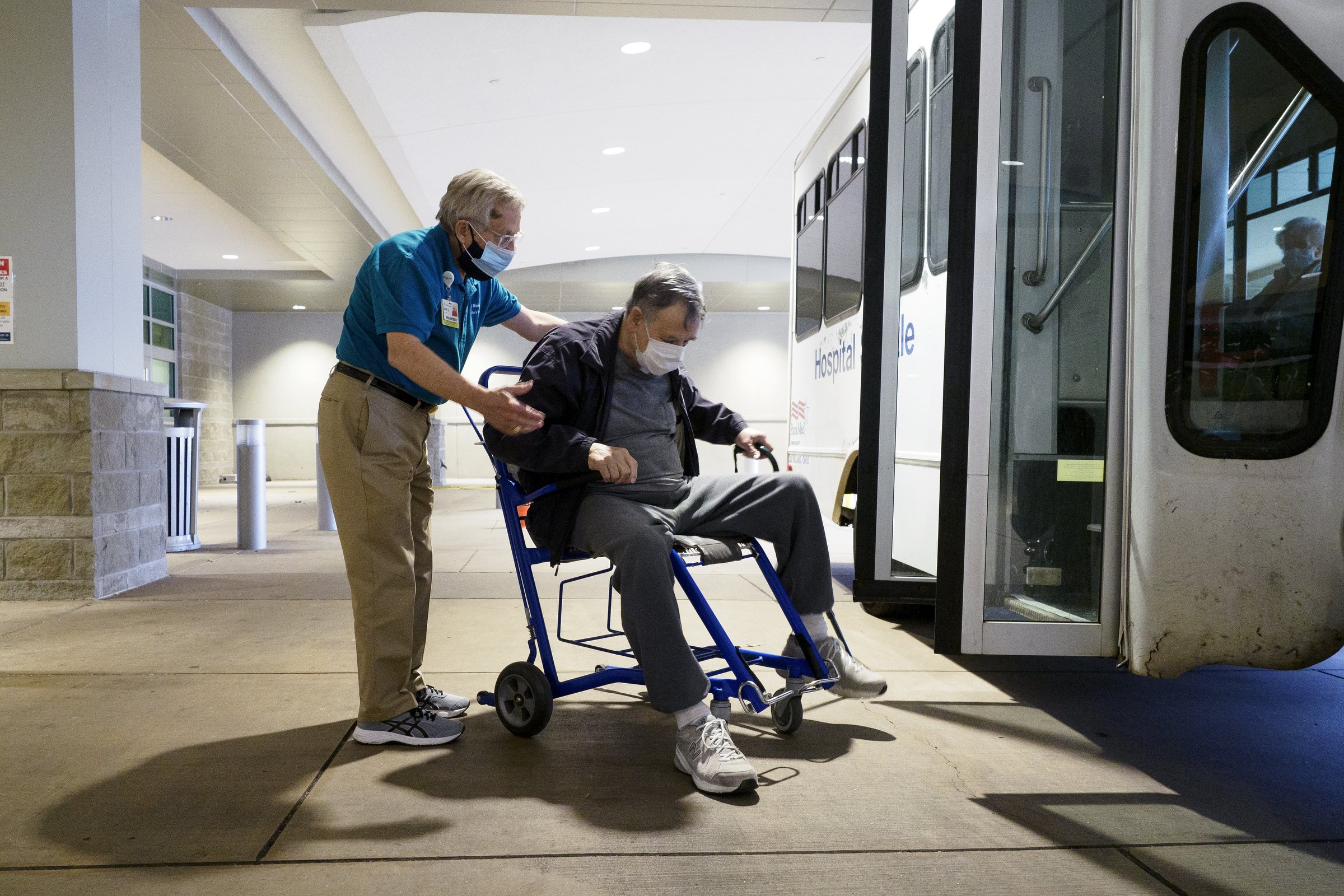 Staff photo by C.B. Schmelter / Volunteer John Vass helps Gilbert Roberts get onto the shuttle at CHI Memorial Hospital on Monday, Feb. 1, 2021 in Chattanooga, Tenn. The hospital welcomed back volunteers who have been fully vaccinated.