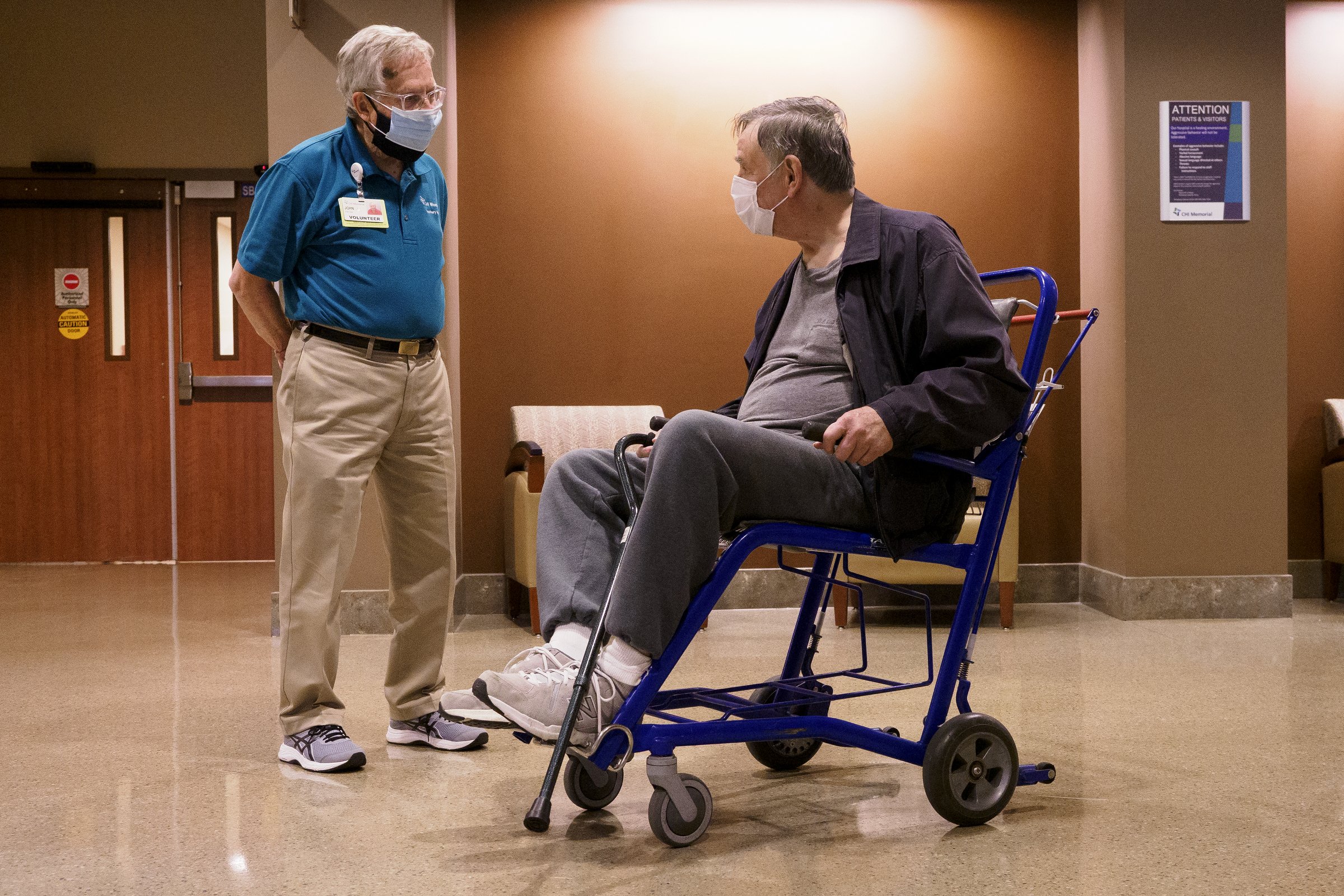 Staff photo by C.B. Schmelter / Volunteer John Vass, left, talks to Gilbert Roberts at CHI Memorial Hospital on Monday, Feb. 1, 2021 in Chattanooga, Tenn. The hospital welcomed back volunteers who have been fully vaccinated.