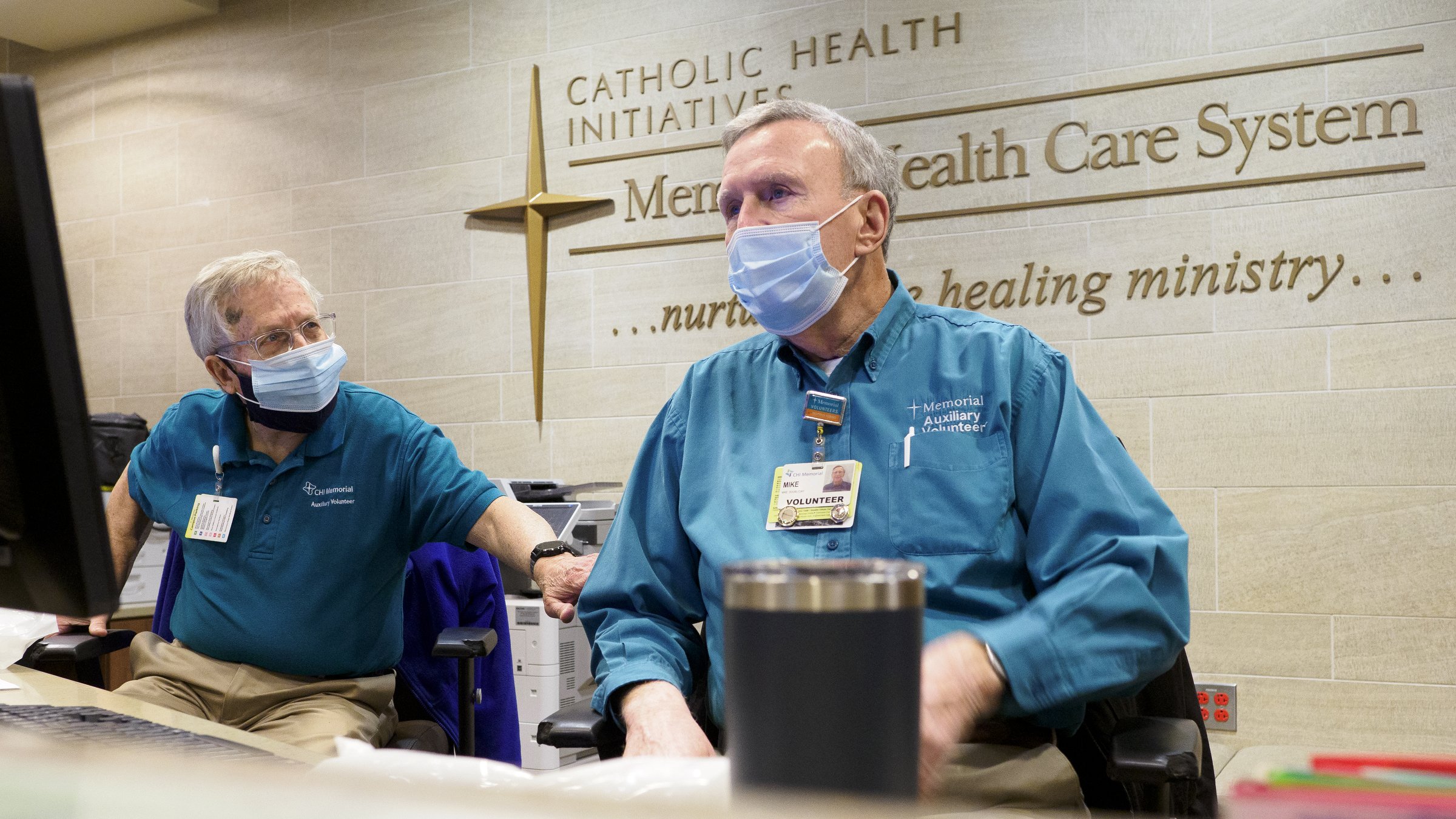 Staff photo by C.B. Schmelter / Volunteers John Vass, left, and Mike Doubleday chat at CHI Memorial Hospital on Monday, Feb. 1, 2021 in Chattanooga, Tenn. The hospital welcomed back volunteers who have been fully vaccinated.