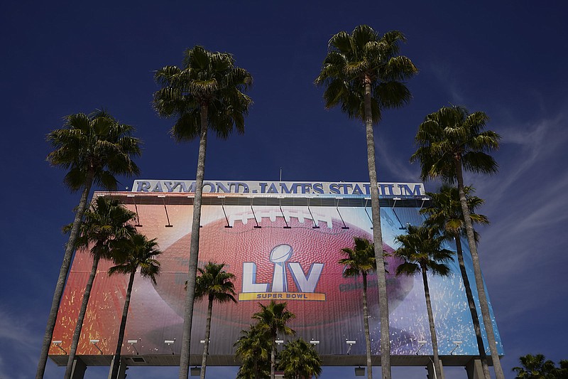 AP photo by Charlie Riedel / A sign for Super Bowl LV is framed by palm trees at Raymond James Stadium on Thursday in Tampa, Fla. The Tampa Bay Buccaneers will become the NFL's first team to play a Super Bowl on their own field when they face the Kansas City Chiefs, the reigning champions.