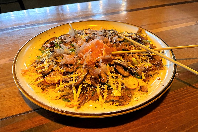 Contributed Photo by Anne Braly / Flying Squirrel's Japanese pancake, okonomiyaki, is assembled like a pizza with a crust of battered and grilled cabbage and onions topped with sesame seeds, glazed shiitake mushrooms, orange peel, pickled ginger and other add-ons.