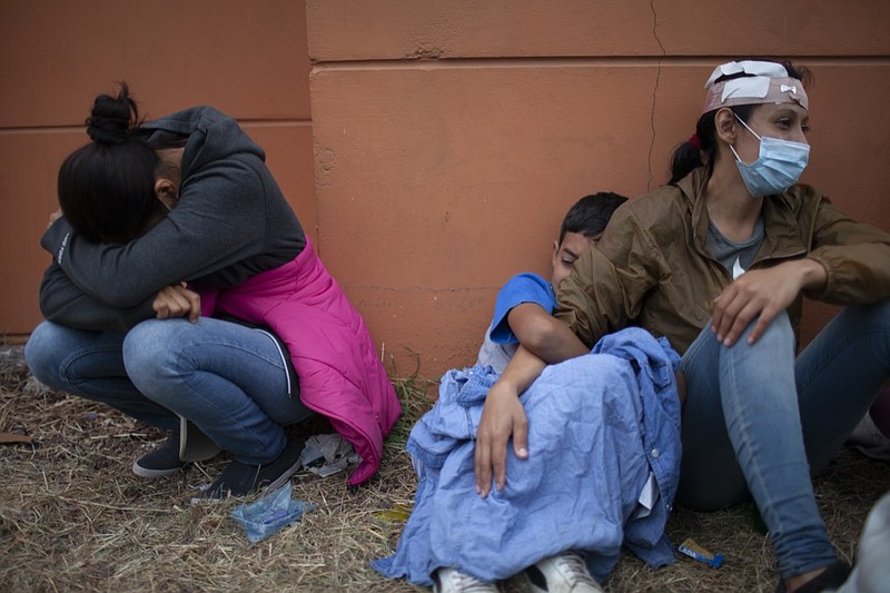 FILE - In this Jan. 17, 2021, file photo injured women, part of a Honduran migrant caravan in their bid to reach the U.S. border, weep as they sit on the side of a highway after clashing with Guatemalan police and soldiers in Vado Hondo, Guatemala, Guatemala. U.S. Federal law allows immigrants facing credible threats of persecution or violence in their home country to seek U.S. asylum. (AP Photo/Sandra Sebastian, File)