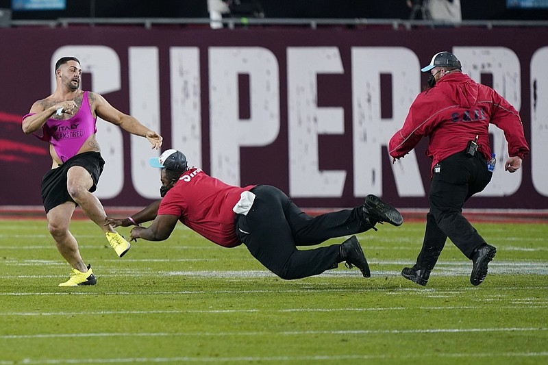 Security tries to grab a fan on the field during the second half of the NFL Super Bowl 55 football game between the Tampa Bay Buccaneers and the Kansas City Chiefs, Sunday, Feb. 7, 2021, in Tampa, Fla. (AP Photo/Mark Humphrey)