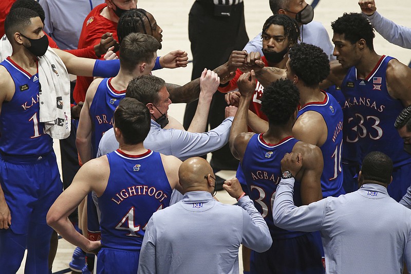 Kansas coach Bill Self meets with players during the second half of an NCAA college basketball game against West Virginia, Saturday, Feb. 6, 2021, in Morgantown, W.Va. (AP Photo/Kathleen Batten)