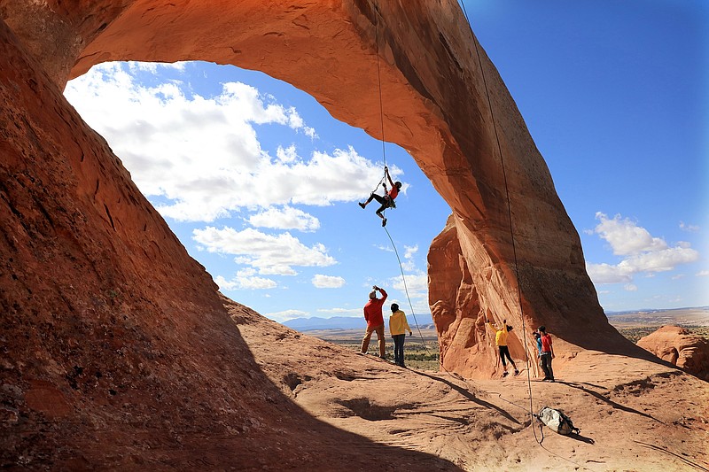 Contributed Photo from MacGillivray Freeman Films / A climber dangles beneath the graceful stone curve of Wilson Arch in Utah's Arches National Park in a scene from "Into America's Wild 3D," a new Imax film opening Feb. 12 at the Tennessee Aquarium's Imax Theater.