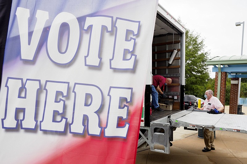 Staff photo by C.B. Schmelter / Election Official Kelly Beltinck, center, and Election Deputy David Torbett work on unloading a truck while setting up for early voting at the Brainerd Youth and Family Development Center on Monday, Oct. 12, 2020, in Chattanooga, Tenn.