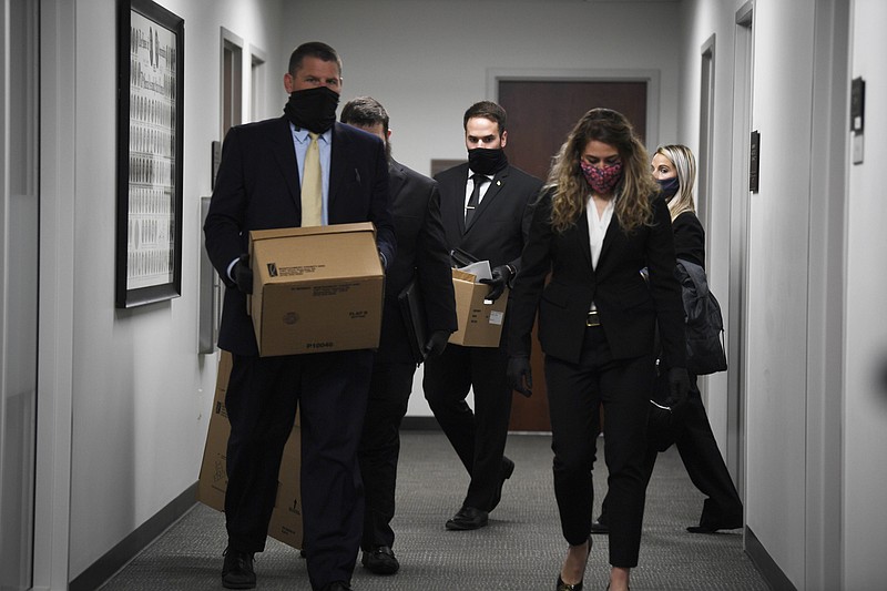  In this Friday, Jan. 8, 2021, file photo, FBI agents carry boxes as they search legislative offices at the Cordell Hull State Office Building in Nashville, Tenn. Campaign finance officials offered little sympathy Wednesday, Feb. 10, 2021, to a newly sworn-in Republican Rep. Todd Warner, who said he was unable to complete a recent election finance report due to the FBI confiscating all his campaign files. Warner was one of several state lawmakers whose homes and legislative offices were searched by federal agents earlier this year. (Stephanie Amador/The Tennessean via AP, File)