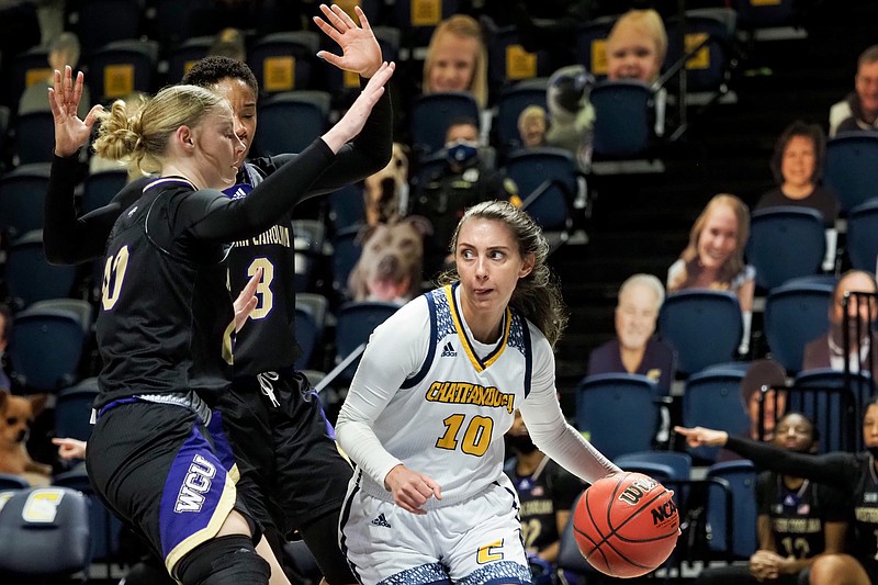 Staff file photo by C.B. Schmelter / UTC's Dena Jarrells dribbles past a pair of Western Carolina defenders Thursday at McKenzie Arena. The Mocs rolled to a 74-45 win that night, then completed the series sweep with a harder-fought 72-58 victory on Saturday at McKenzie.