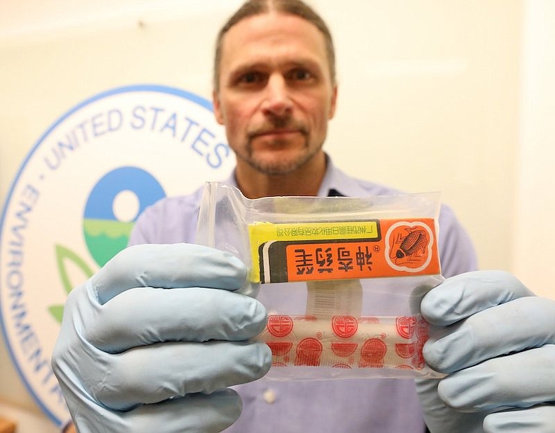 Chad Schulze, an EPA Pesticide Enforcement Officer, displays one of the banned pesticides that Amazon was selling online. (Greg Gilbert/The Seattle Times/TNS)