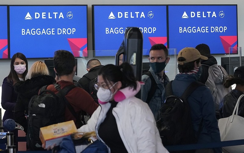 FILE - In this Dec. 22, 2020 file photo, people wait in line at a Delta Air Lines gate at San Francisco International Airport during the coronavirus pandemic in San Francisco. U.S. airlines are pressing their case against requiring coronavirus testing of passengers on domestic flights. The CEOs of several major airlines met Friday, Feb. 12, 2021 with the White House's coronavirus-response coordinator to lobby against a testing requirement. (AP Photo/Jeff Chiu, file)