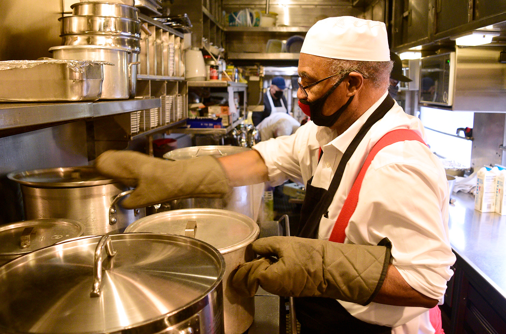 Staff Photo by Robin Rudd / Chef Robert Ellison arranges pots on the kitchen car's gas stove.