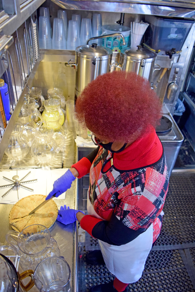 Staff Photo by Robin Rudd / Kitchen Staff member Barbara Ellison cuts a apple pie.