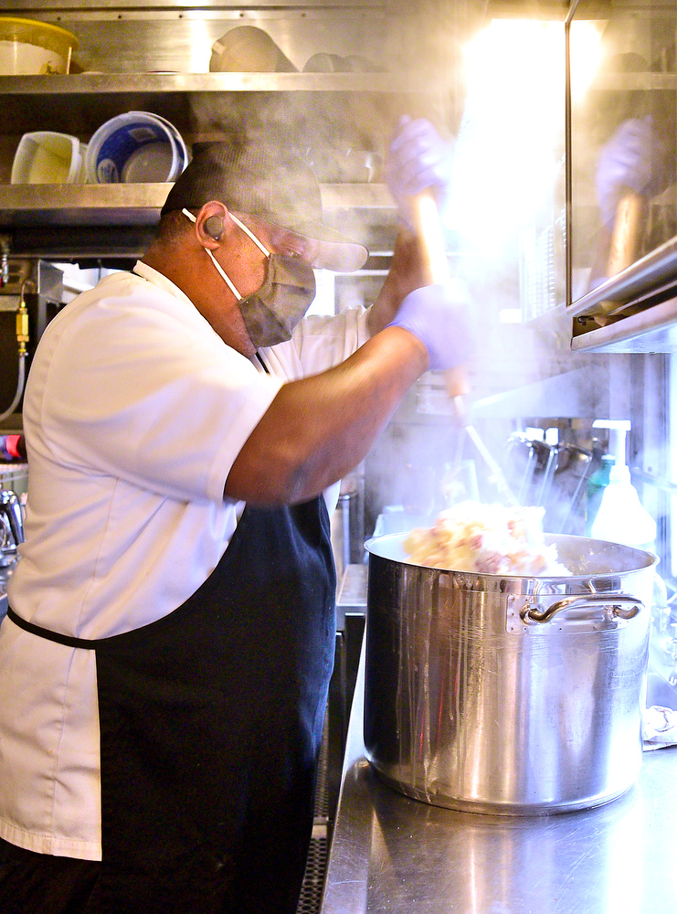 Staff Photo by Robin Rudd / Chef Terrence Smith is enveloped in steam as he mashes potatoes in the kitchen car.