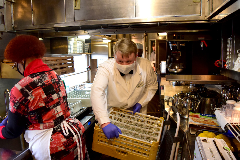 Staff Photo by Robin Rudd / Justin Freeman slips past Barbara Ellison in the kitchen car.