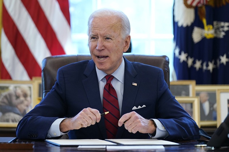 FILE - In this Jan. 28, 2021 file photo, President Joe Biden signs a series of executive orders in the Oval Office of the White House in Washington. Biden campaigned on raising the national minimum wage to $15 per hour and attached a proposal doing just that to the $1.9 trillion coronavirus pandemic relief bill. (AP Photo/Evan Vucci)