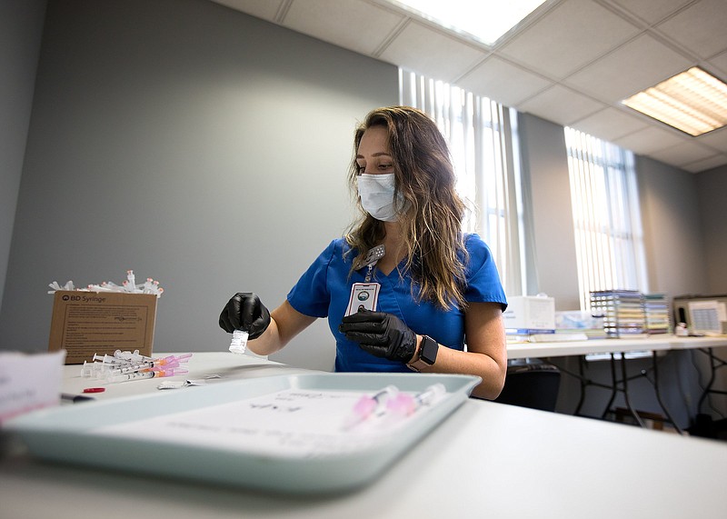 Staff photo by Troy Stolt / Nurse Lauren Dean fills syringes with the Moderna COVID-19 vaccine inside of the pharmacy at the Hamilton County Health Department's new COVID Vaccination POD at the CARTA Bus Terminal on Thursday, Jan. 28, 2021, in Chattanooga, Tenn.