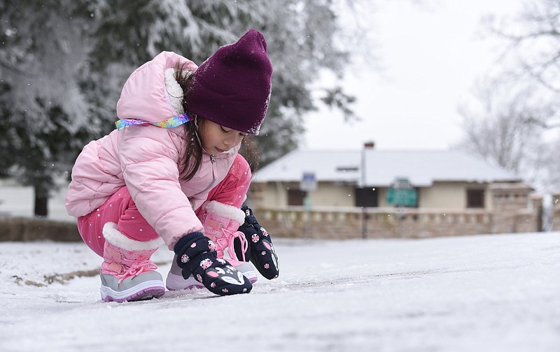 Staff Photo by Matt Hamilton / Irish Francisco, 5, of Americus, Ga., scrapes together snow to make a snowball near the entrance to Point Park on Lookout Mountain during the snowfall on Tuesday, Feb. 16, 2021. Several school districts around Chattanooga closed schools or went fully virtual Tuesday due to snow and ice in the area.