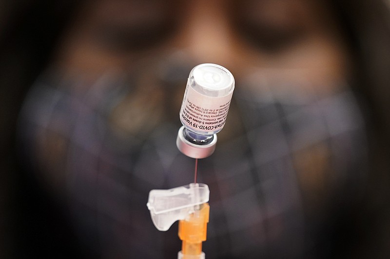 AP file photo by John Locher / In this Jan. 22 file photo, Tina Killebrew, a certified medical assistant, prepares a dose of the Pfizer-BioNTech COVID-19 vaccine at a vaccination center at the University of Nevada, Las Vegas. The makers of COVID-19 vaccines are figuring out how to tweak their recipes against worrisome virus mutations — and regulators are looking to flu as a blueprint if and when the shots need an update.