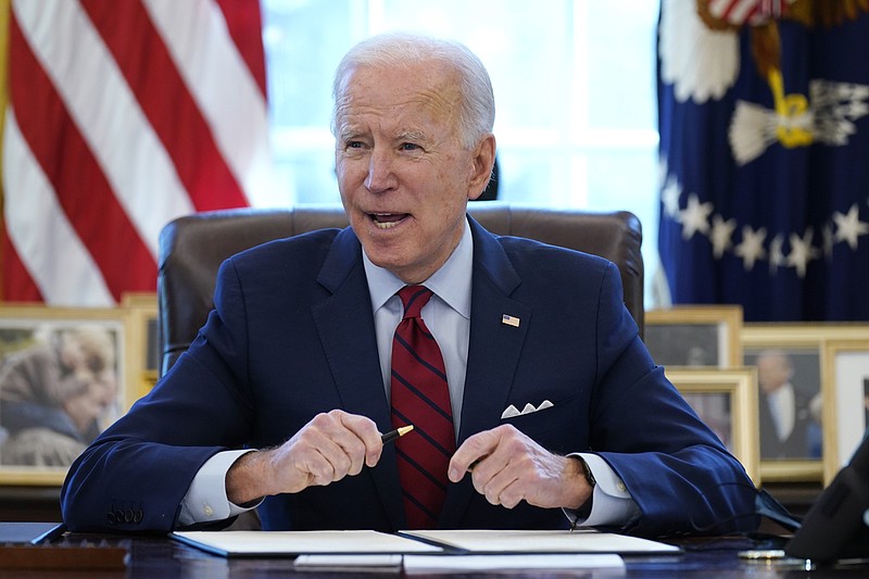 FILE - In this Jan. 28, 2021 file photo, President Joe Biden signs a series of executive orders in the Oval Office of the White House in Washington. Biden campaigned on raising the national minimum wage to $15 per hour and attached a proposal doing just that to the $1.9 trillion coronavirus pandemic relief bill. (AP Photo/Evan Vucci)