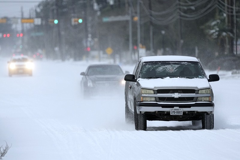 Vehicles drive on snow and sleet covered roads Monday, Feb. 15, 2021, in Spring, Texas. A winter storm dropping snow and ice sent temperatures plunging across the southern Plains, prompting a power emergency in Texas a day after conditions canceled flights and impacted traffic across large swaths of the U.S. (AP Photo/David J. Phillip)