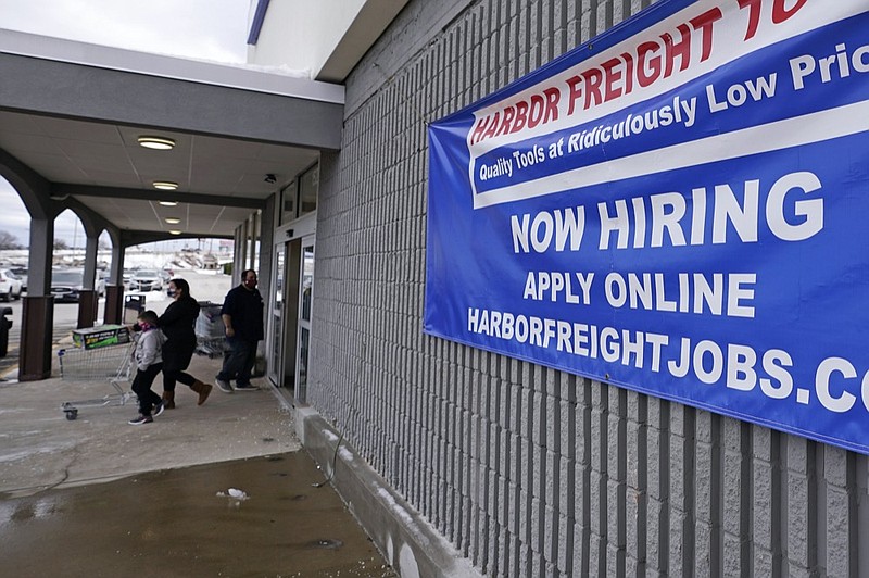 FILE - In this Dec. 10, 2020 file photo, a "Now Hiring" sign hangs on the front wall of a Harbor Freight Tools store in Manchester, N.H. U.S. employers cut back sharply on hiring in December, particularly in pandemic-hit industries such as restaurants and hotels, as soaring virus infections and government restrictions weakened the economy that month.  (AP Photo/Charles Krupa, File)


