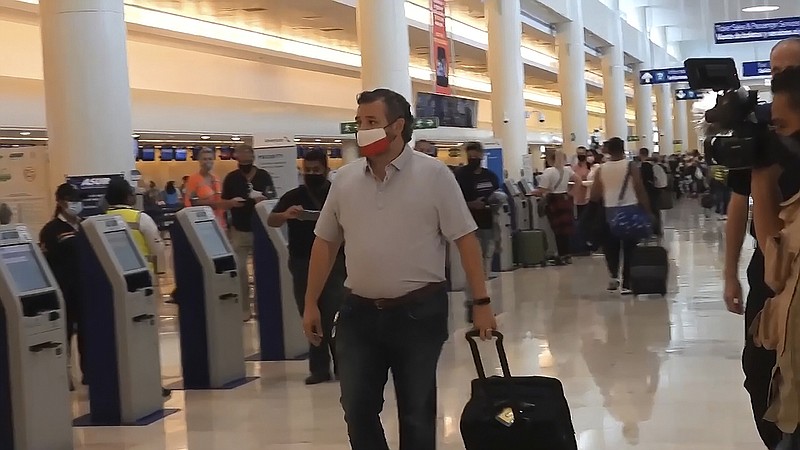 Photo by Dan Christian Rojas of The Associated Press / In this image from video, Sen. Ted Cruz, R-Texas, walks to check in for his flight back to the U.S. at Cancun International Airport in Cancun, Mexico, on Thursday, Feb. 18, 2021.