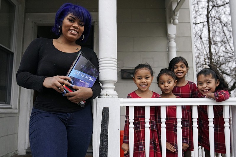 Dinora Torres, a MassBay Community College student, poses with her four daughters on the front porch of their home, Thursday, Jan. 14, 2021, in Milford, Mass. At the college, applications for meal assistance scholarships have increased 80% since last year. Among the recipients is Torres, who said the program helped keep her enrolled. (AP Photo/Charles Krupa)


