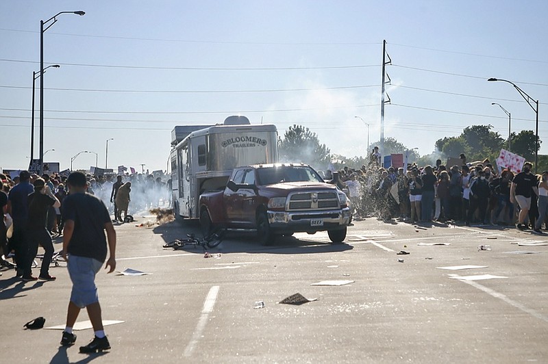 FILE - In this Sunday, May 31, 2020 file photo, a truck drives through a group of protesters who had shut down Interstate 244 during a rally in Tulsa, Okla. The march was to mark the anniversary of the 1921 Tulsa race massacre and to protest the death George Floyd, who died May 25 after he was pinned at the neck by a Minneapolis police officer. (Ian Maule/Tulsa World via AP, File)


