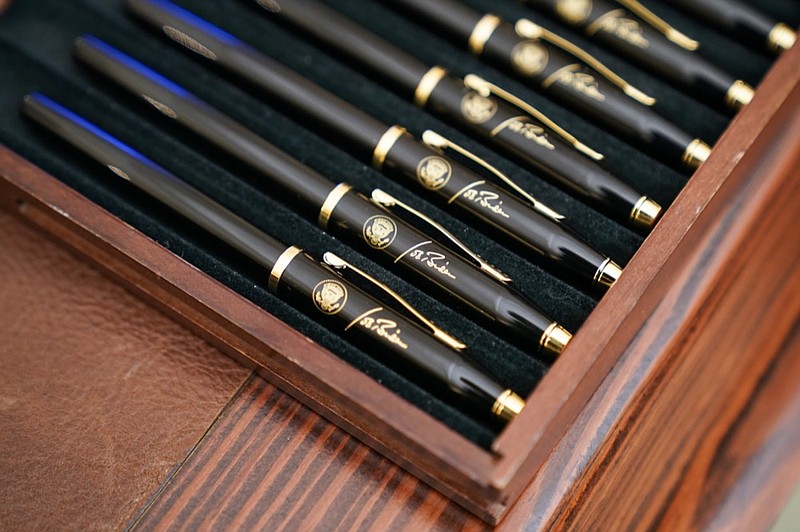 FILE - In this Jan. 21, 2021, file photo pens featuring President Joe Biden's signature and presidential seal, are displayed in the State Dinning Room of the White House in Washington. (AP Photo/Alex Brandon, File)


