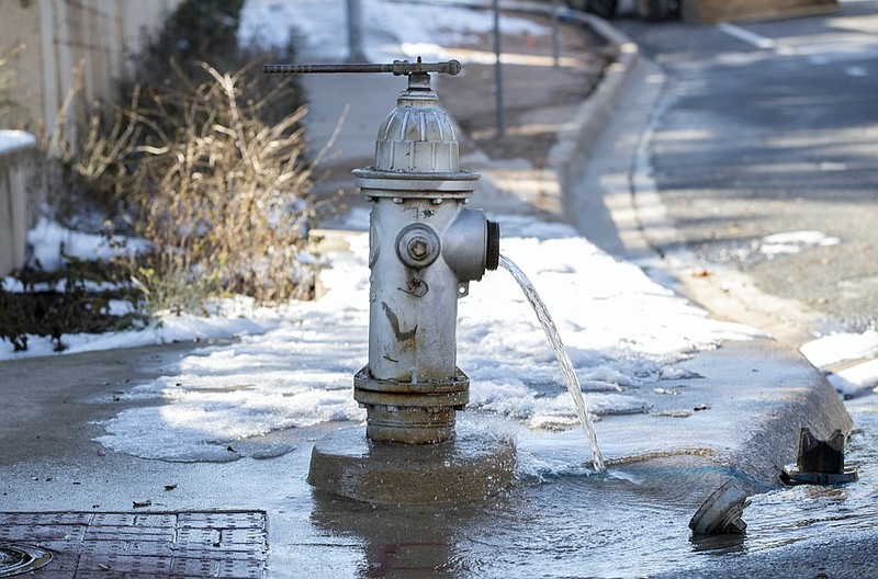 Water trickles from a fire hydrant while City of Austin Water Utility workers repair a broken water main near 11th and Red River streets in Austin, Texas, on Friday, Feb. 19, 2021./ (Jay Janner/Austin American-Statesman via AP)


