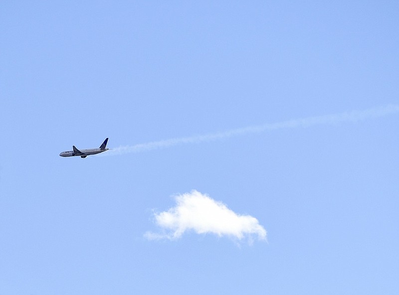 A United Airlines plane with smoke trailing from its right side is seen heading east towards Denver International Airport, Saturday, Feb. 20, 2021 in Broomfield, Colo . Debris from a United Airlines plane fell onto Denver suburbs during an emergency landing Saturday, with one very large piece that appears to be part of the engine narrowly missing a home. (Andy Cross/The Denver Post via AP)