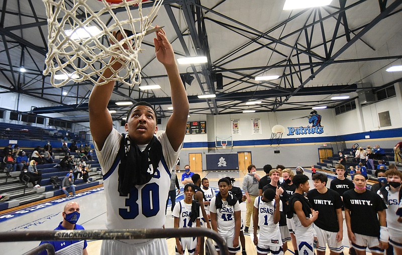 Staff Photo by Matt Hamilton / CSAS (30) Johnny McFarland helps cut down the net after the Patriots win over Tellico Plains at Chattanooga School of Arts and Sciences on Monday, Feb. 22, 2021. 