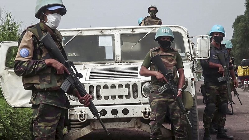 In this image taken from video, United Nations peacekeepers guard the area where a U.N. convoy was attacked and the Italian ambassador to Congo killed, in Nyiragongo, North Kivu province, Congo Monday, Feb. 22, 2021. The Italian ambassador to Congo Luca Attanasio, an Italian carabineri police officer and their Congolese driver were killed Monday in an attack on a U.N. convoy in an area that is home to myriad rebel groups, the Foreign Ministry and local people said. (AP Photo/Justin Kabumba)