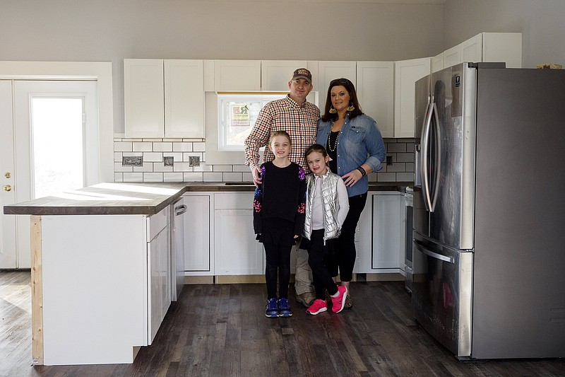 Staff photo by C.B. Schmelter / Christi and Chris Perry pose with their daughters DellaMae, 8, left, and CoraLee, 6, at their home remodel in Soddy-Daisy. The couple won Chatter's DIY Contest for their work to transform a cinder block structure into a cozy home which they hope to move into in the next few months.