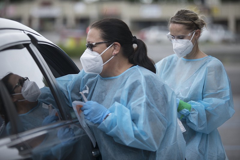 Staff photo by Troy Stolt / Tonya Schuman and Rachel Tripp conduct a coronavirus test at a COVID-19 testing site put on by CEMPA and La Paz on Thursday, July 30, 2020 in Chattanooga, Tenn.