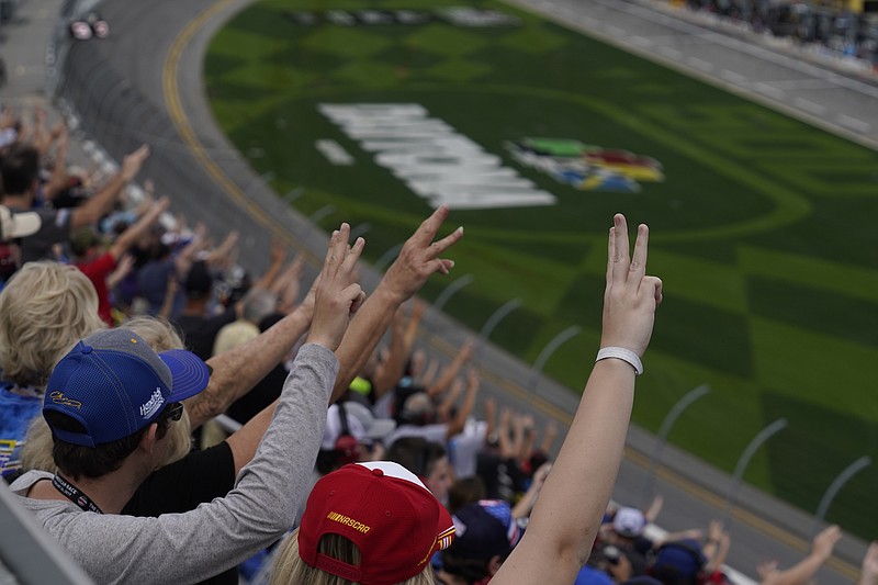 Fans hold up three fingers during a lap three tribute honoring the late Dale Earnhardt, Sr., during the NASCAR Daytona 500 auto race at Daytona International Speedway, Sunday, Feb. 14, 2021, in Daytona Beach, Fla. Dale Earnhardt, Sr., the all-time winner at Daytona, was killed in a fatal car crash at the speedway 20-years ago today. (AP Photo/Chris O'Meara)