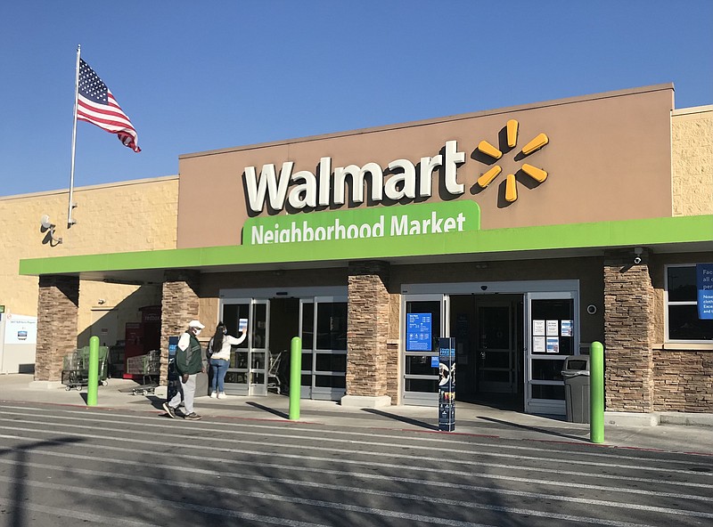 Photo by Dave Flessner / A Walmart worker puts up the notice Wednesday of the pharmacy closing of the Shallowford Road Neighborhood Market. The pharmacy will close March 12 and the grocery store will shut down March 26.