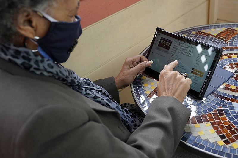 Lynnette White uses her tablet while interviewed in San Francisco, Tuesday, Feb. 16, 2021. The pandemic has sparked a surge of online shopping across all ages as people stay away from physical stores. But the biggest growth has come from consumers 65 and older. (AP Photo/Jeff Chiu)