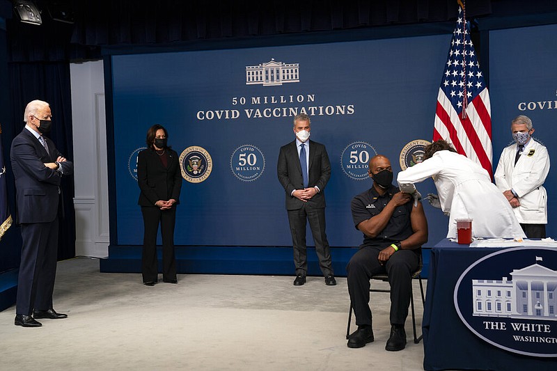President Joe Biden looks on as Washington DC firefighter and EMT Gerald Burn receives a vaccination, during an event to commemorate the 50 millionth COVID-19 shot, in the South Court Auditorium on the White House campus, Thursday, Feb. 25, 2021, in Washington. From left, Biden, Vice President Kamala Harris, White House COVID-19 Response Coordinator Jeff Zients, Burn, registered nurse Elizabeth Galloway, and director of the National Institute of Allergy and Infectious Diseases Dr. Anthony Fauci. (AP Photo/Evan Vucci)