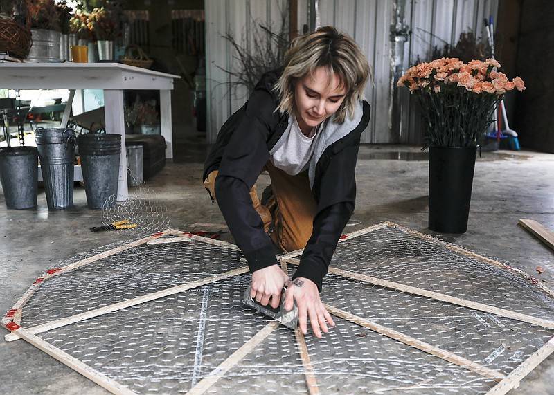 Staff photo by Troy Stolt / Erin Leonard works to create a heart-shaped frame for a floral memorial for those who've lost loved ones from COVID-19 as part of the Floral Heart Project, a national initiative meant to create a memorial for COVID-19 around the country at Joli Jardin Farm on Friday, Feb. 26, 2021 in Signal Mountain, Tenn.