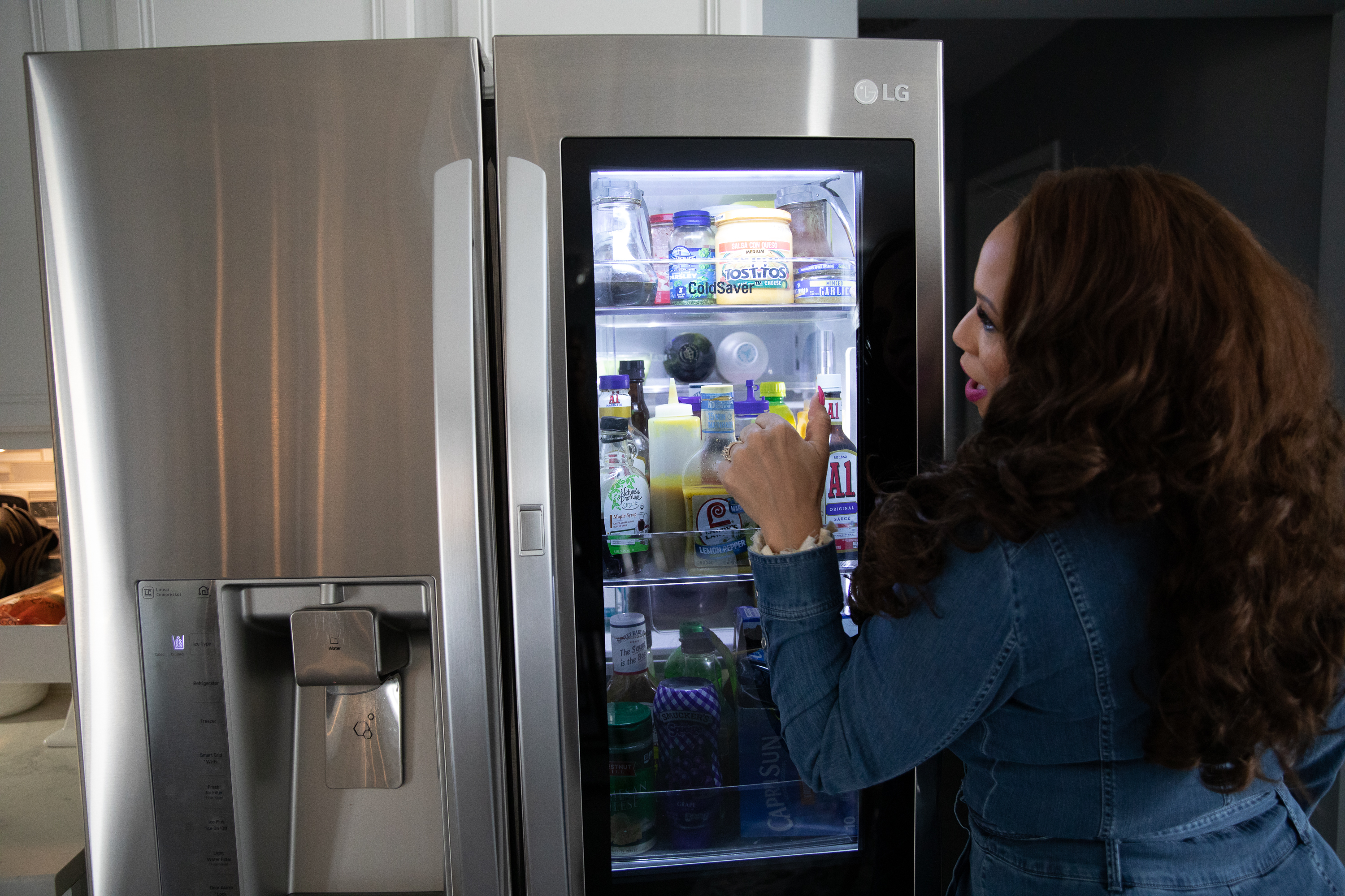 Robyn Penniegraft with her main refrigerator in Greensboro, N.C. Penniegraft can tap the door to reveal what's inside. / Photo by Swikar Patel/The New York Times
