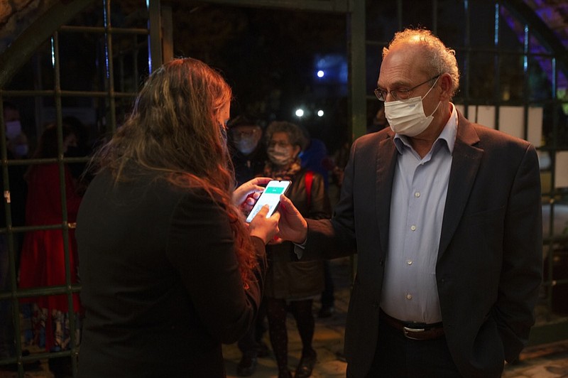 A man presents his "green passport," proof that he is vaccinated against the coronavirus, on opening night at the Khan Theater for a performance where all guests were required to show proof of vaccination or full recovery from the virus, in Jerusalem, Tuesday, Feb. 23, 2021. (AP Photo/Maya Alleruzzo)


