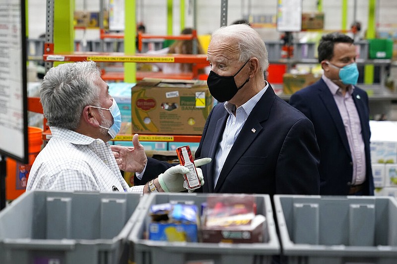 President Joe Biden talks with a volunteer at the Houston Food Bank, Friday, Feb. 26, 2021, in Houston. (AP Photo/Patrick Semansky)