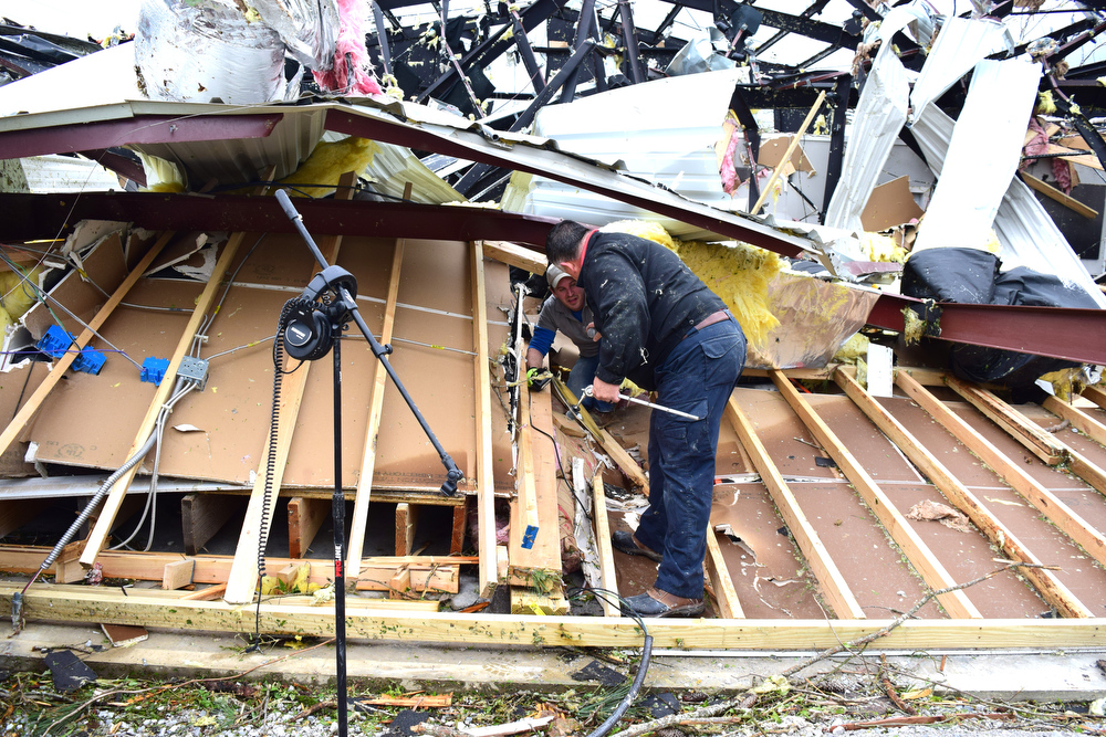 Staff Photo by Robin Rudd / Cornerstone Apostolic Church pastor Raymond Sloan, front, and church member, Daron Ackerson, search through the rubble of their building. The Chattanooga Area was hit by EF 3 tornado on the night of April 12, 2020.