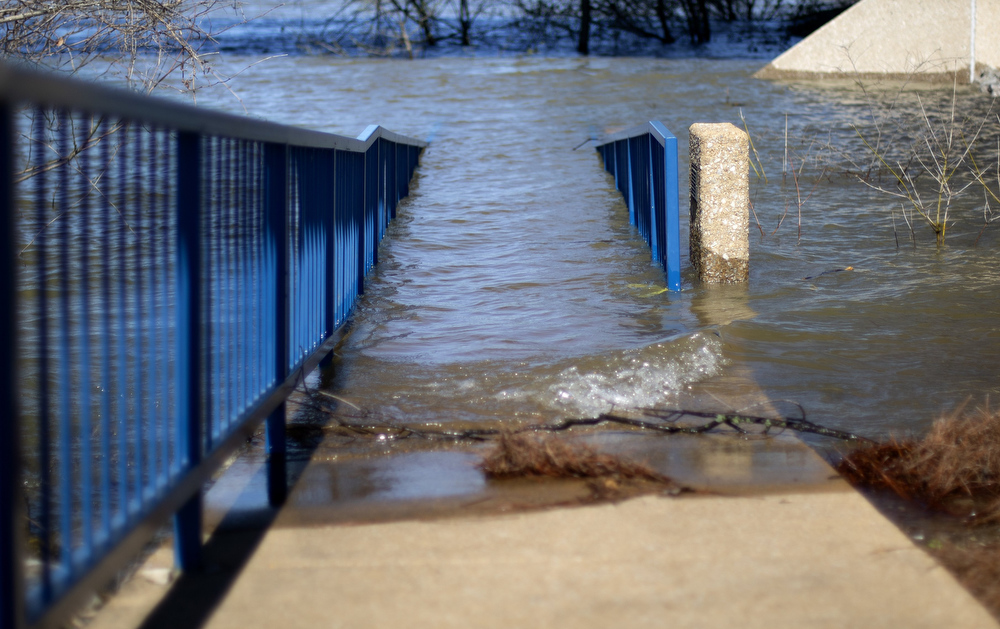 Staff photo by C.B. Schmelter / Flood waters cover a ramp leading towards Gibson Pier at the Tennessee Riverpark on Wednesday, March 25, 2020 in Chattanooga, Tenn. Despite the sunshine, recent rains have caused the Tennessee River to swell up and flood parts of the park. This has led to the Hamilton County Parks and Recreation Department to close parts of the trail, boat ramps and piers.