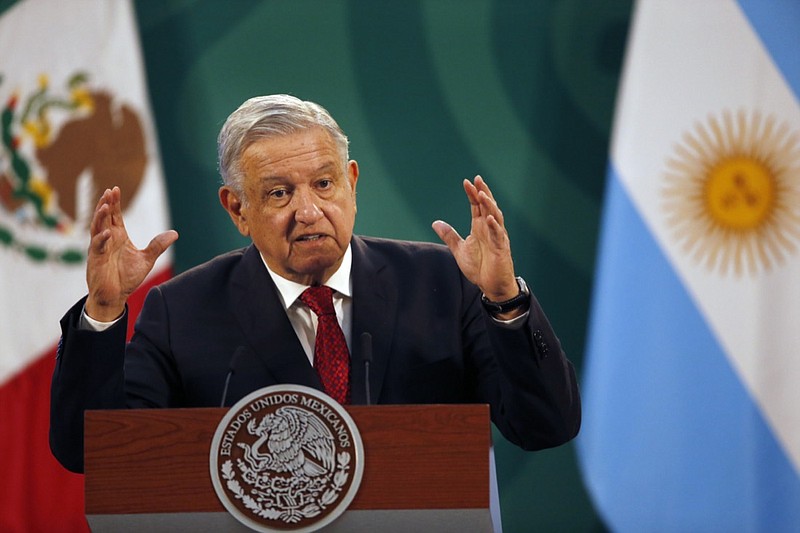 Mexican President Andrés Manuel López Obrador gives his daily, morning press conference at the National Palace in Mexico City, Tuesday, Feb. 23, 2021, with an Argentine flag in the background, right, as Argentine President Alberto Fernandez attends the event. (AP Photo/Marco Ugarte)